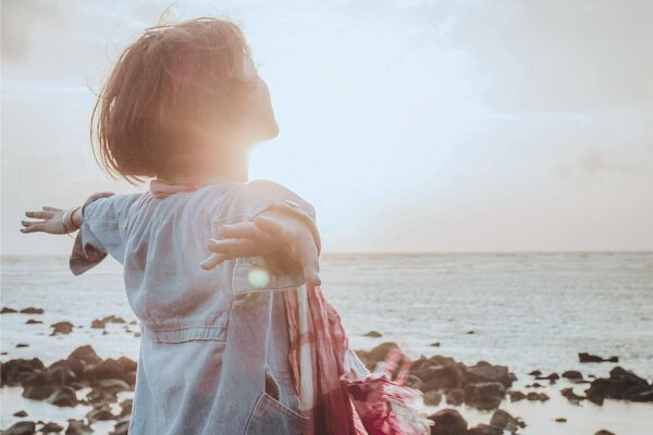 Foto de niña admirando jugando en un paisaje en el que se siente felíz